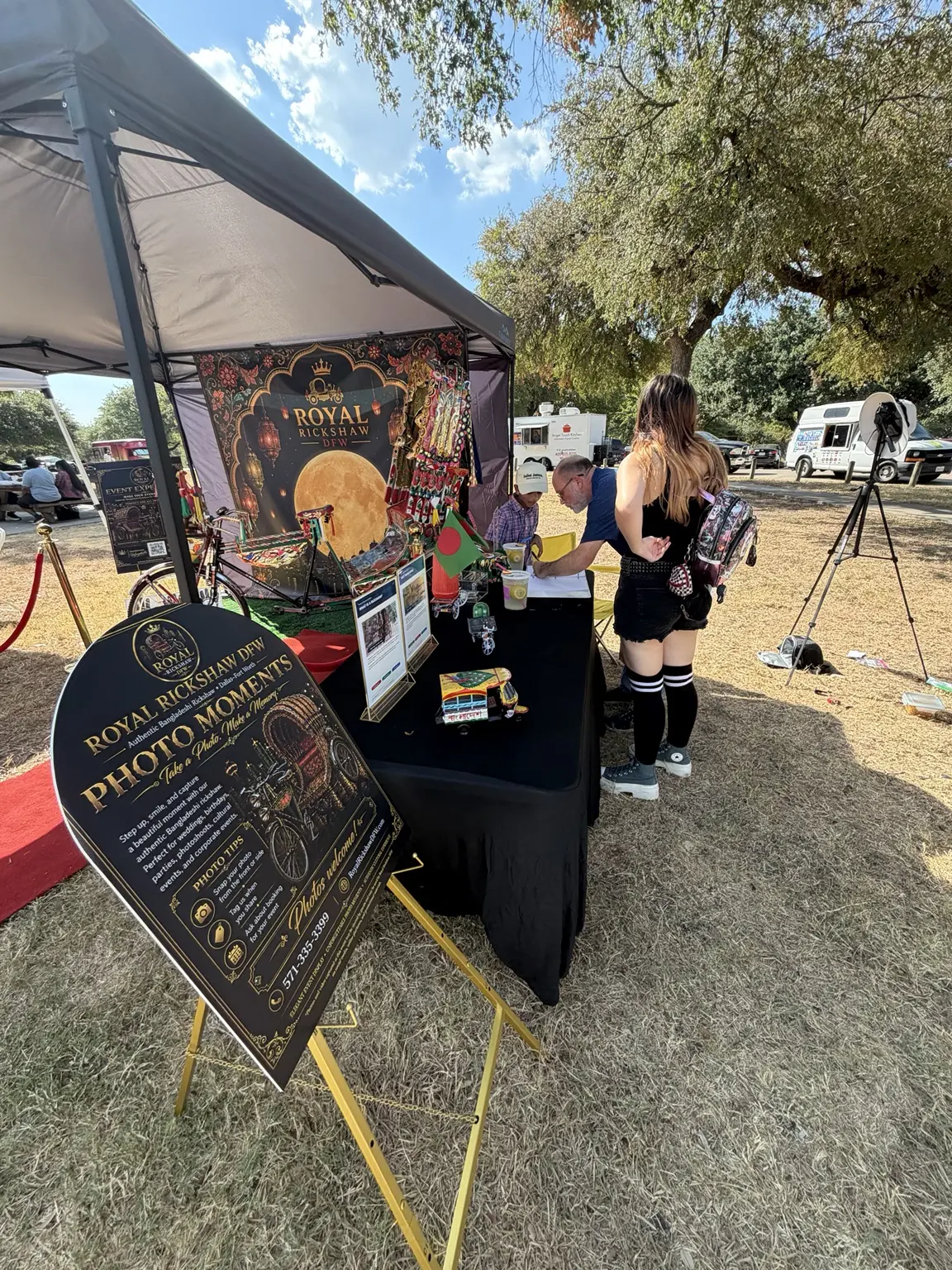 Visitors learning about Royal Rickshaw DFW at the festival booth
