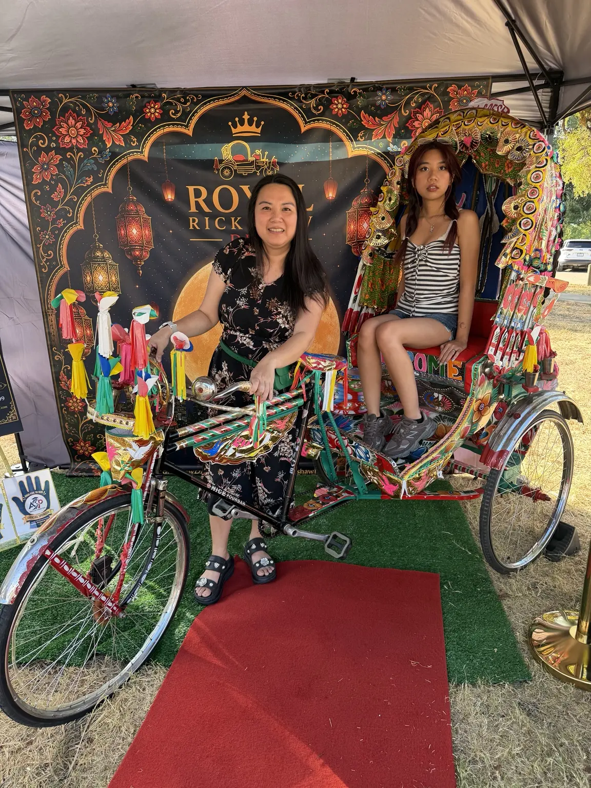 Two young festival guests smiling from the authentic Bangladeshi rickshaw