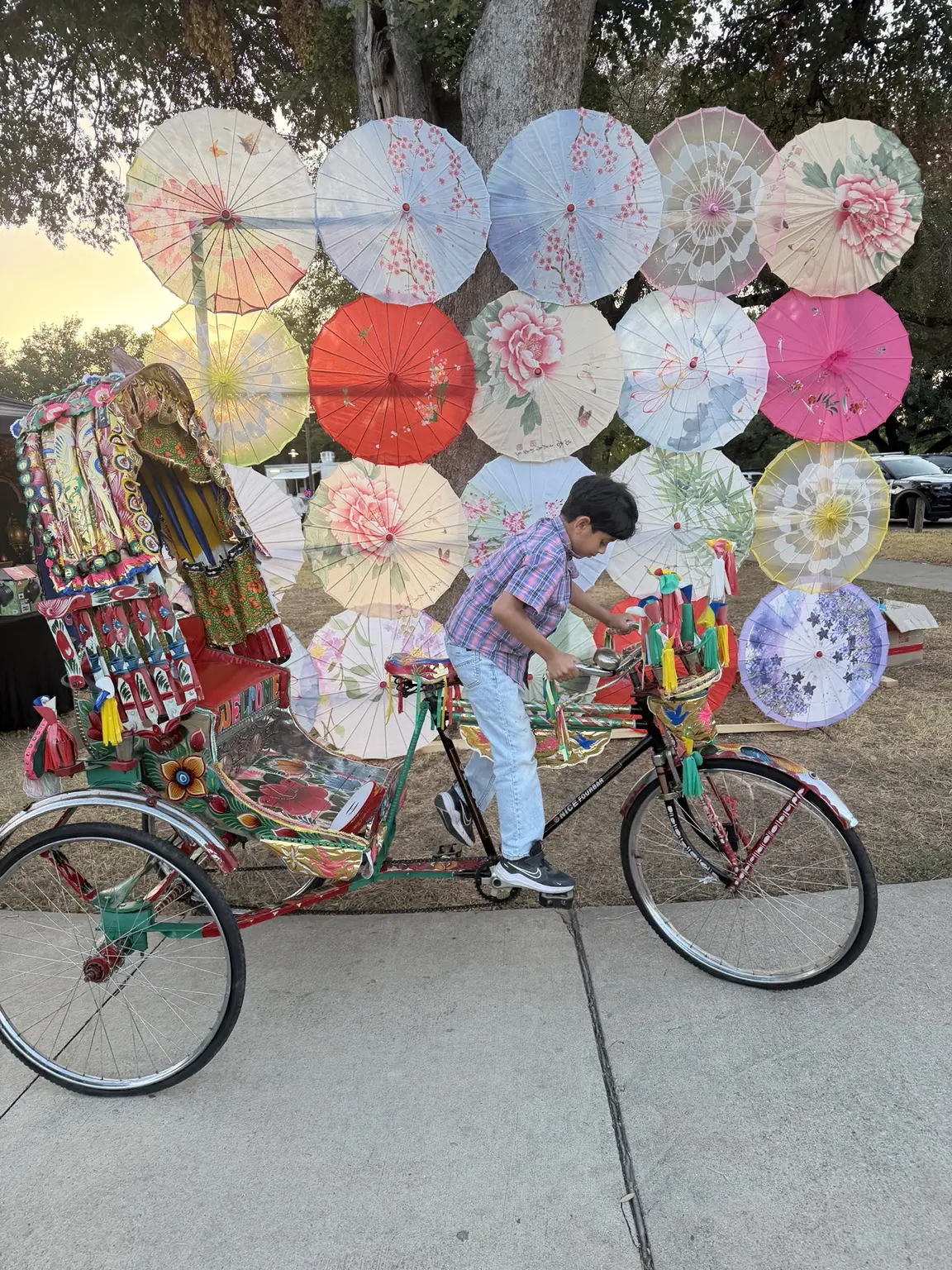 Side view of the authentic rickshaw beneath a canopy of colorful decorated umbrellas