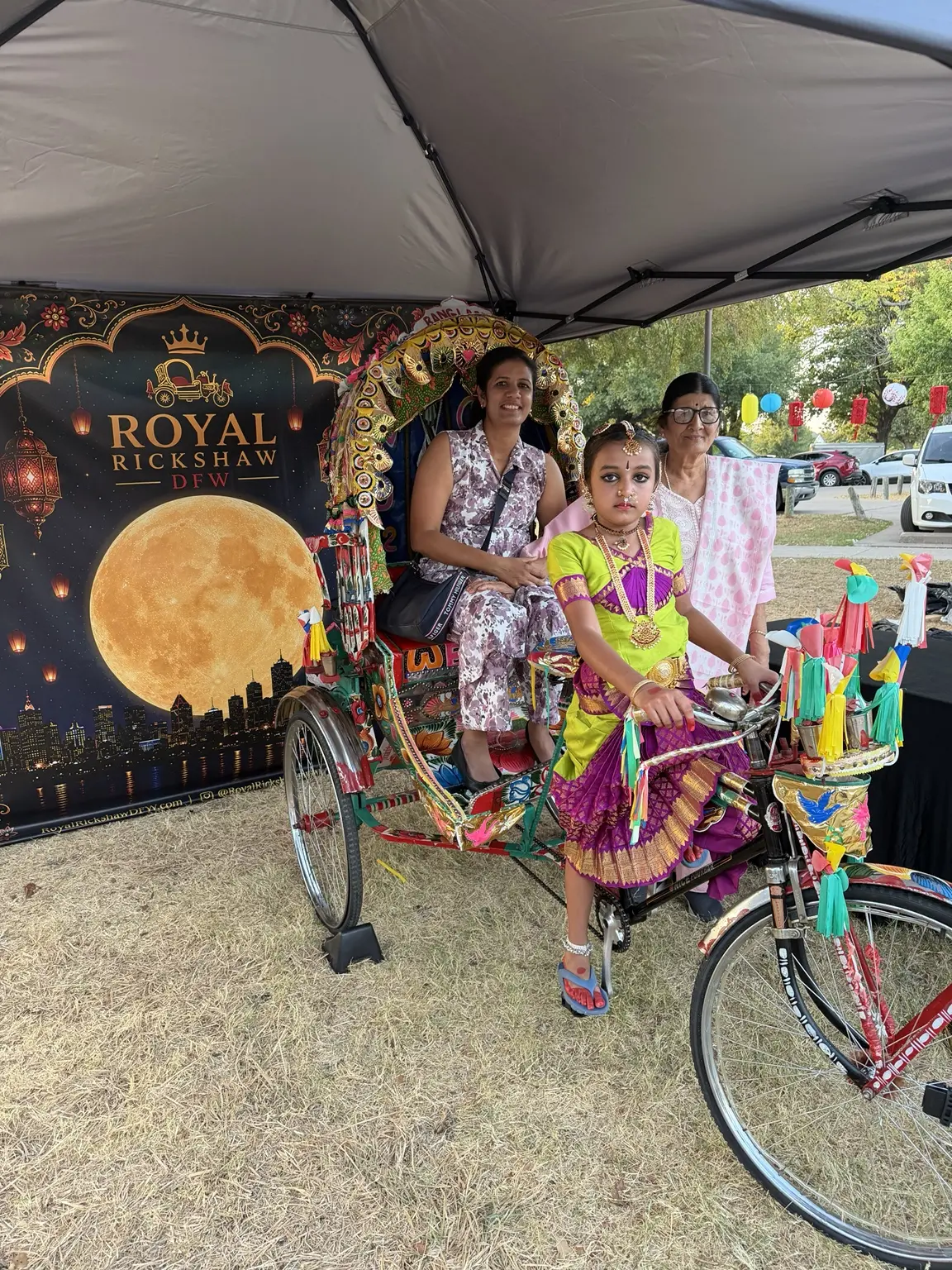 Family group gathered around the Royal Rickshaw at Dallas Moon Festival