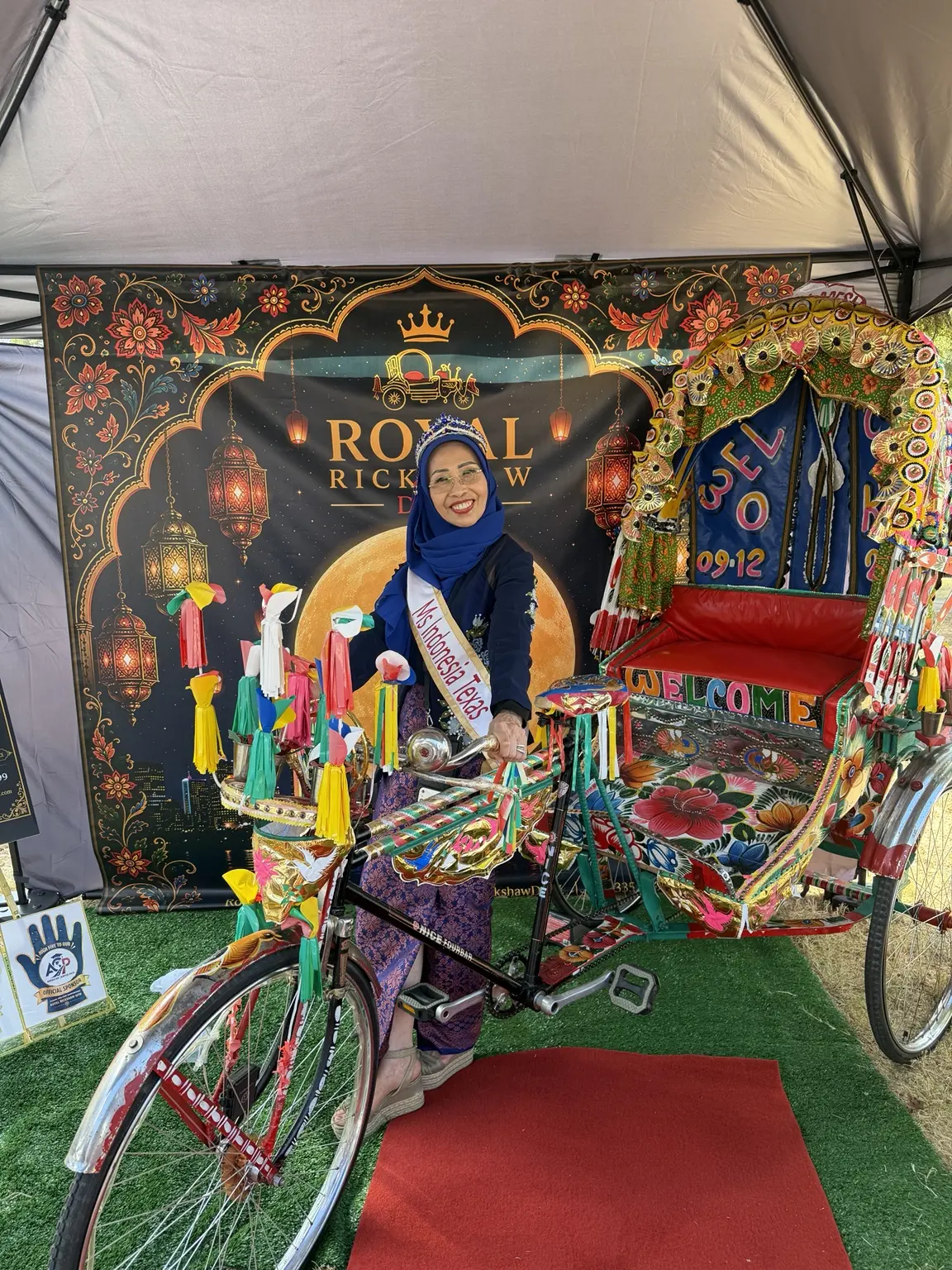 Festival performer in blue traditional dress posing with the Royal Rickshaw