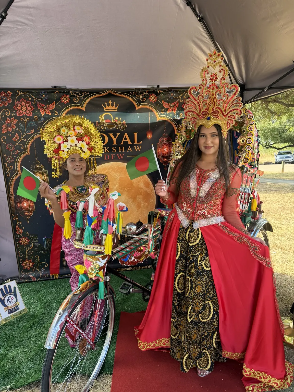 Two cultural performers in ornate traditional costumes with the rickshaw