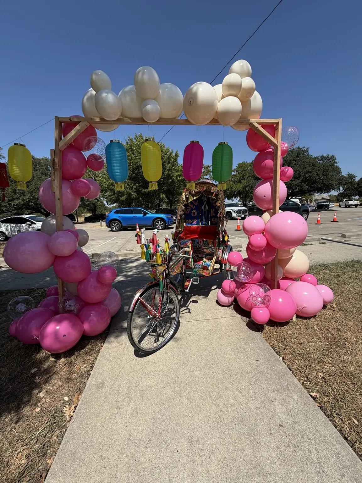 Authentic Bangladeshi rickshaw displayed beneath a colorful balloon arch