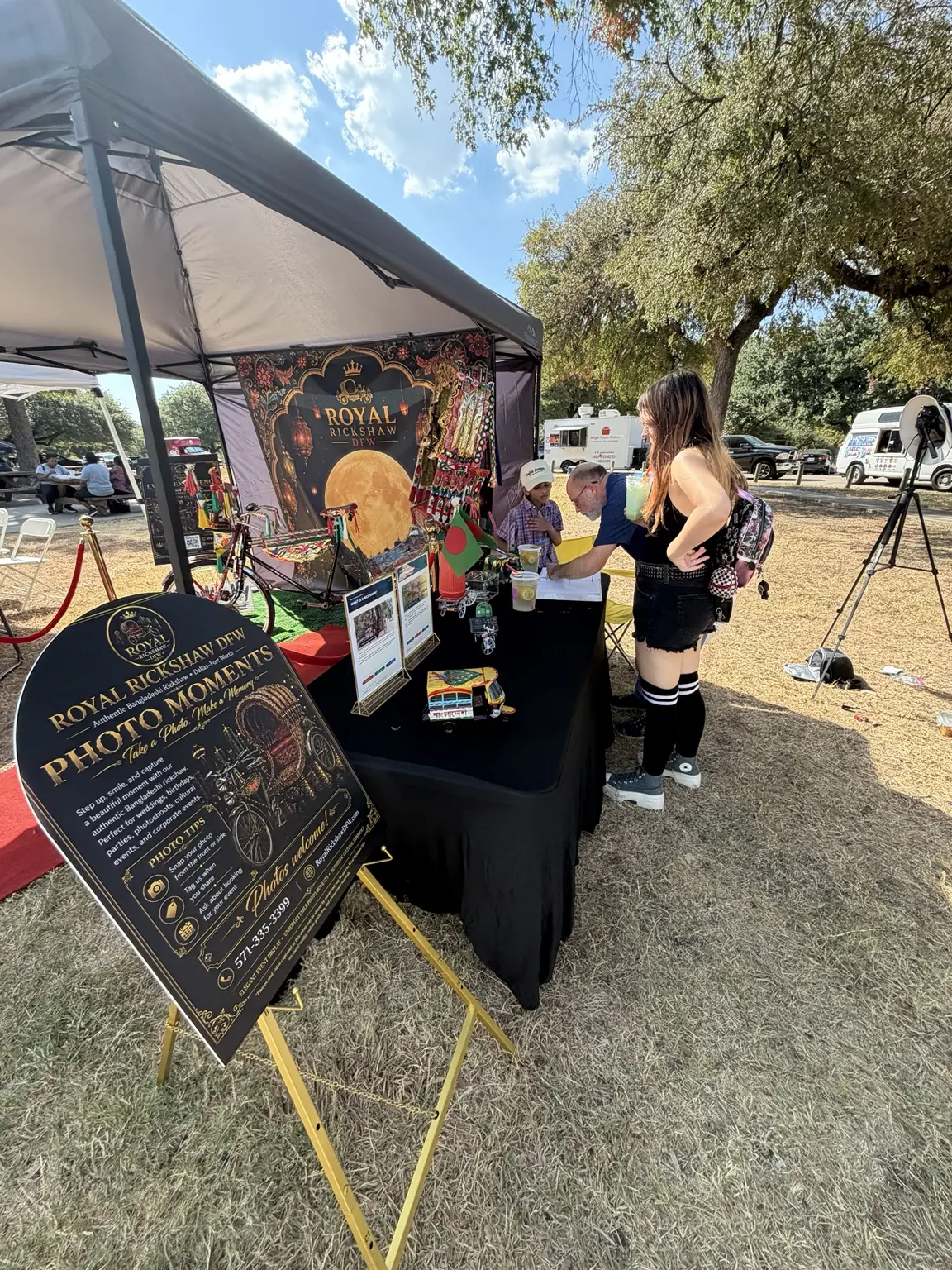 Visitors speaking with the Royal Rickshaw DFW team at the festival booth