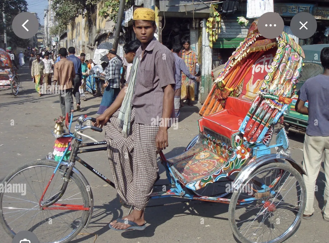 Reference image of a decorated rickshaw and driver on a Bangladesh street