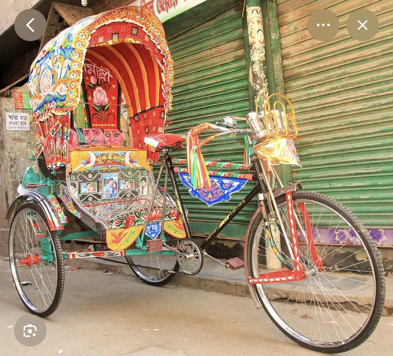 Reference image of a highly decorated rickshaw against a city storefront