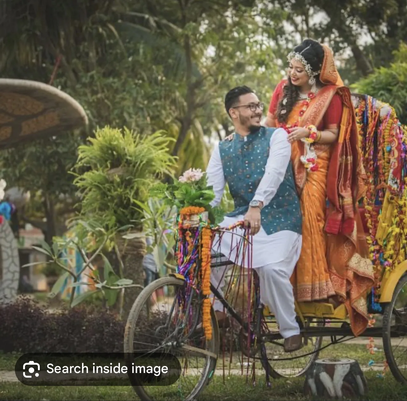 Reference image of a bride and groom posing with a colorful rickshaw